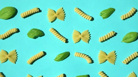 Uncooked curly pasta and basil leaf pattern on blue background. Traditional 스톡 동영상 137111002