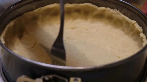 Uncooked Dough Crust in Round Springform Pan with Fork Piercing Stock Footage 298166464