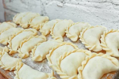 Uncooked dumplings on the kitchen board Stock Photos