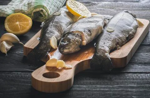 Uncooked fish on a cutting board Stock Photos