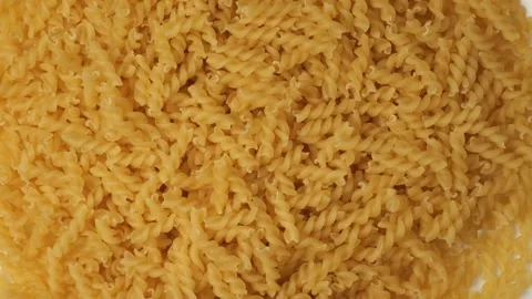 Uncooked fusilli pasta rotating in a loop Stock Footage 341281128