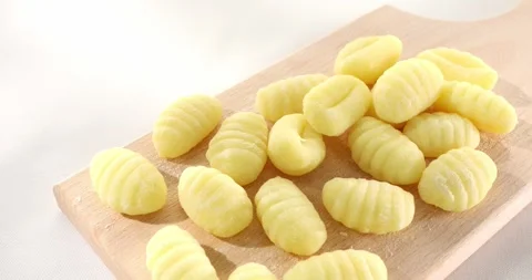 Uncooked gnocchi on cutting board Stock Footage 243346086
