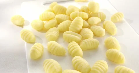 Uncooked gnocchi on cutting board Stock Footage 243575524