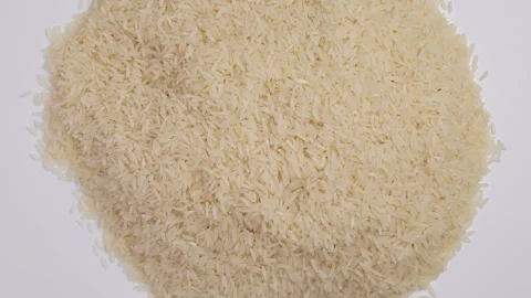 Uncooked Jasmin Rice on white rotating. Stockbeeldmateriaal 247347849
