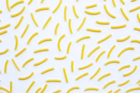 Uncooked macaroni on a white background. Stock Photos