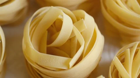Uncooked noodle nest . Slow motion video.slow motion pasta dry tagliatelle spin Stock Footage 169282827