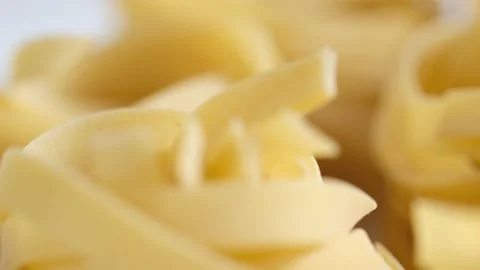 Uncooked noodle nest . Slow motion video.slow motion pasta dry tagliatelle spin Stock Footage 169440595