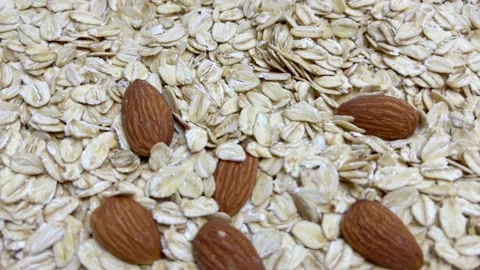 Uncooked oatmeal flakes texture and almonds close up. Macro shot Rotation Stock Footage 158549850