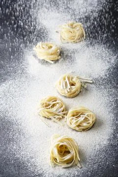 Uncooked pasta with flour on the table Stock Photos