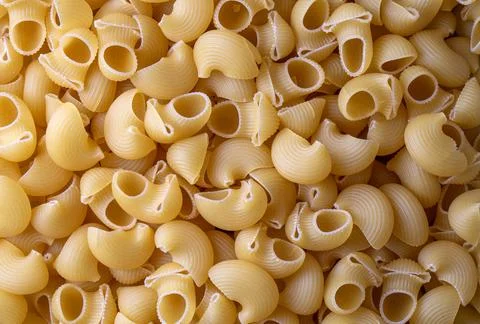 Uncooked pipe rigate pasta background. Italian raw pasta. Stock Photos
