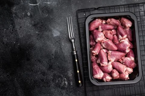Uncooked poultry hearts in container, dark backdrop accentuates rich pink hue Stock Photos