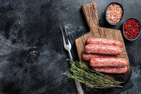 Uncooked Raw beef and lamb meat kebabs sausages on a wooden board. Black Stock Photos