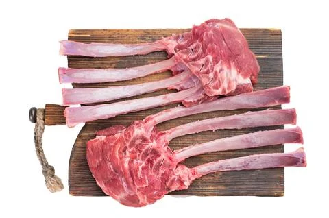 Uncooked raw lamb rack bone ribs in meat arranged on wooden cutting board i.. Stock Photos