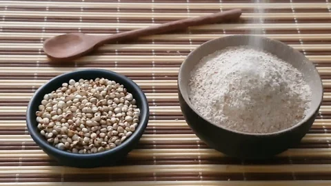 Uncooked raw Sorghum flour (also known as sorgo) in a back bowl, isolated Stock Footage 117438430