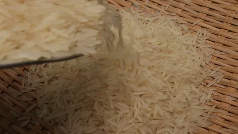 Uncooked raw white long grain rice pour drop fall on bamboo tray spin rotat.. Stock Footage 261982784