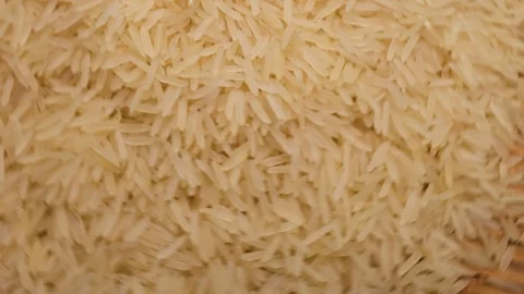 Uncooked raw white long grain rice pour drop fall on bamboo tray spin rotat.. Stock Footage 261982890