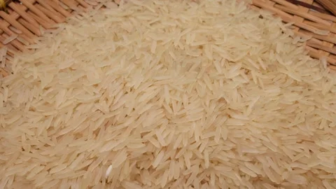 Uncooked raw white long grain rice pour drop fall on bamboo tray spin rotat.. Stock Footage 261983039