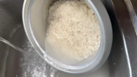 Uncooked rice being washed in water Stock Footage 325300391