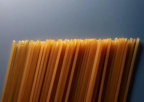 Uncooked spaghetti pasta on gray background, forming a textured pattern and.. Stock Photos