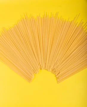 Uncooked yellow long spaghetti on a rustic background. Yellow italian pasta.  Foto stock