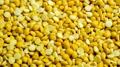 Uncooked yellow split pea lentils scooped up with a wooden spoon, slow motion Stock Footage 65076879