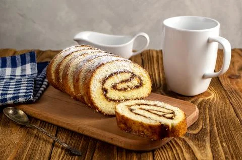 Uncut biscuit roll with fruit jam and powdered sugar on a cutting board, wi.. Stock Photos