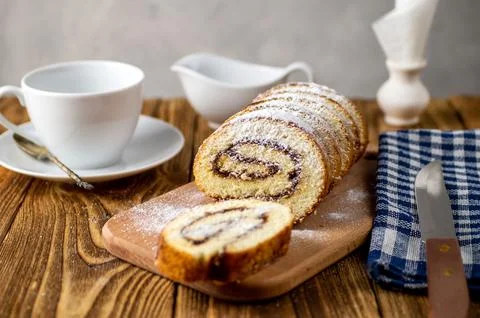 Uncut biscuit roll with fruit jam and powdered sugar on a cutting board, wi.. Stock Photos