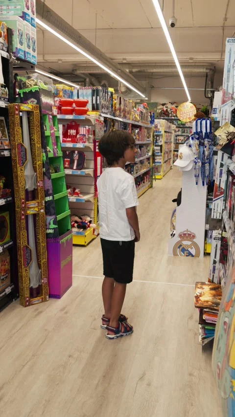 Undecided child looking at shelves full of toys in a big store feeling over.. Stock Footage 338226587