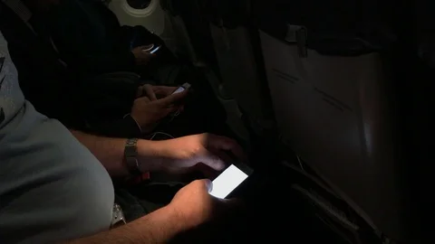 Undefined persons use the cell phone during a travel on airplane medium shot Stock-Footage 85887828