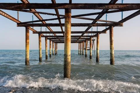 Under the abandoned rusty pier. Stock Photos