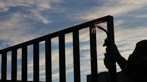 UNDER BLUE SKY OUTSIDE WELDING GATE Stock Footage 32637145