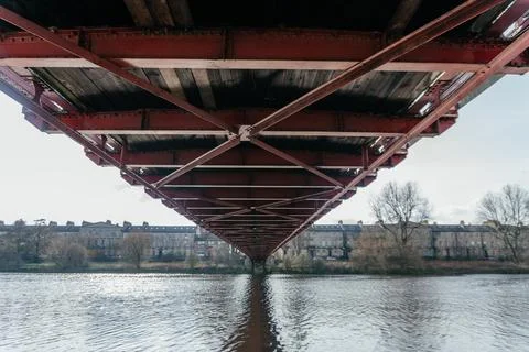 Under the Bridge: Architectural Perspective of Ironwork Over River Stock Photos
