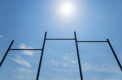 Under a clear blue sky, horizontal gym bars are positioned for athletes to .. 库存照片