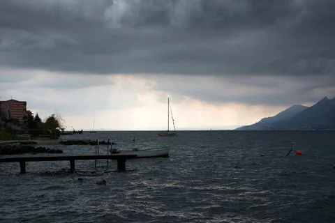 Under a cloudy dark sky, a cold sea with waves. A duck swims in the foregroun Stock Photos