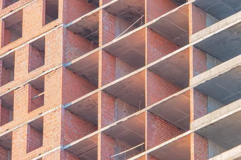 Under construction brick building, red columns and beams, grid pattern, grayw Stock Photos