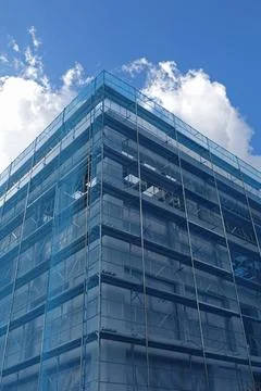 Under construction building covered in blue debris netting Stock-Fotos