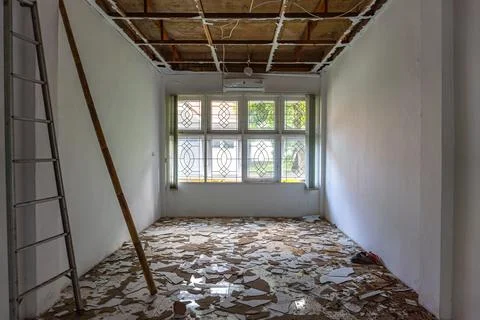 Under construction with damaged ceiling and debris on floor Photos