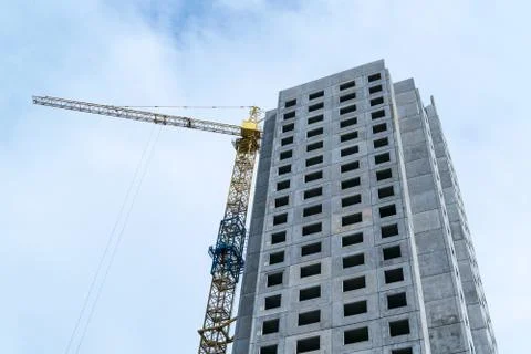 Under construction skyscraper and construction crane. Stock Photos