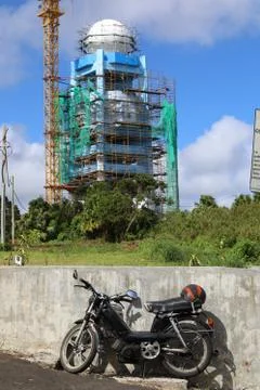 Under construction of a tower and a crane is a motorcycle Stock Photos