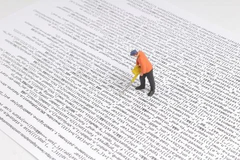 Under Construction worker figurines working on code. Stock Photos