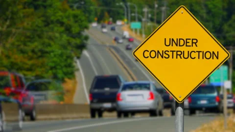Under Construction Yellow Road Traffic Sign and Highway Vehiclesa Stock-Footage 287516215