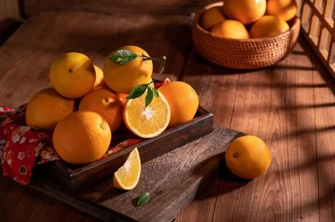 Under the dim light, the oranges on the plate are on the wooden table, like.. Stock Photos