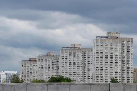 Under the expressive dark sky, covered with rain clouds, a block of high-rise Stock Photos