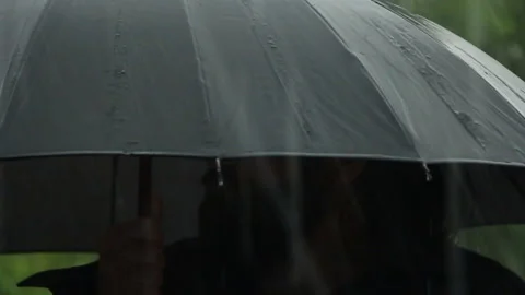 Under a heavy rain, under a black umbrella, stands a man with a beard Stock Footage 109488298