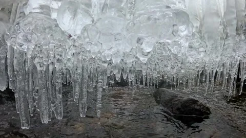 Under the Ice: Slow Motion Crystal Icicles Beneath Frozen Stream at Ken Lockwood Stock Footage 341125592
