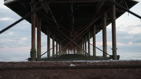 Under Paignton Pier at Dusk Sunset, Waves Splashing Vídeo Stock 224736704