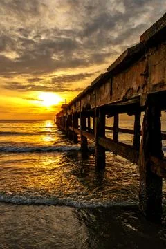 Under the pier beach at sunrise Stock Photos