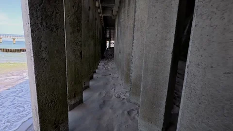 Under the Pier Perspective with Sand and Concrete Columns Stock Footage 312987967