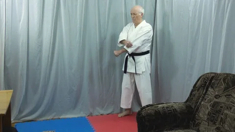 Under quarantine self-isolation conditions, an old athlete trains kick Stock Footage 129790322