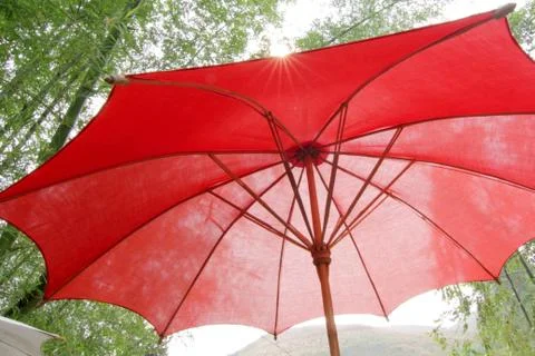 Under the red beach umbrella Stock Photos